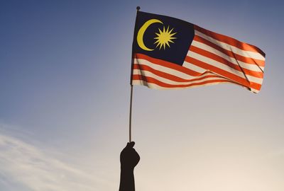 Low angle view of flag flags against sky