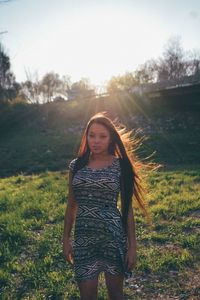 Portrait of young woman standing on field