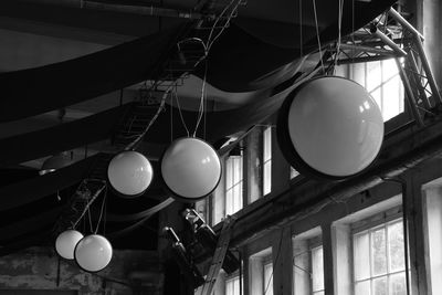 Low angle view of illuminated pendant light hanging from ceiling