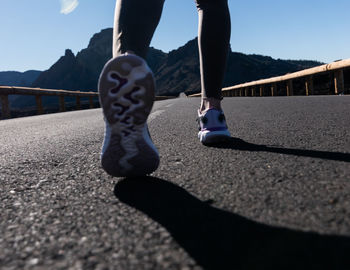 Low section of person walking on road