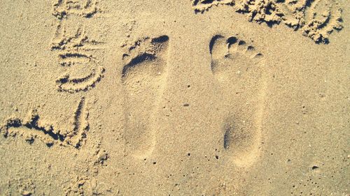 High angle view of footprints on sand at beach