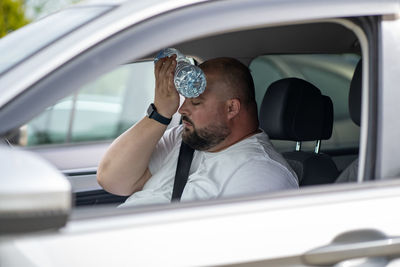 Side view of woman using mobile phone while sitting in car