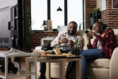 Man and woman using smart phones at home