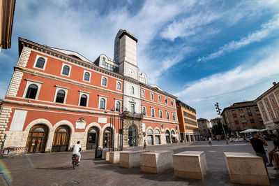 View of buildings in city against cloudy sky