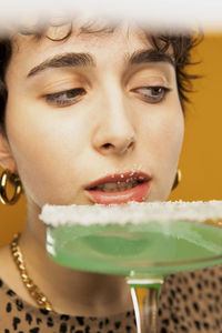 Woman eating sugar on cocktail glass