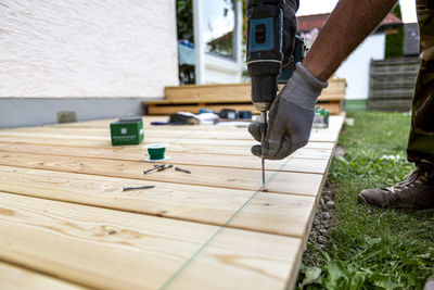 Low section of man standing on wood