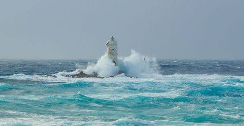 The lighthouse of the mangiabarche shrouded by the waves of a mistral wind storm
