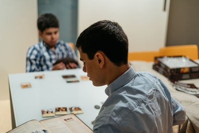 High angle view of siblings studying while sitting at table