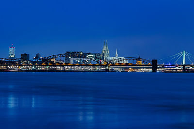 Illuminated bridge over river at night