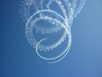 Low angle view of airplane flying against the blue sky