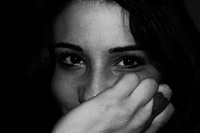 Close-up portrait of young woman covering face