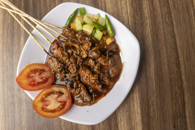 Sate ayam, satays with peanut sauce, famous indonesian cuisine photographed with high angle view