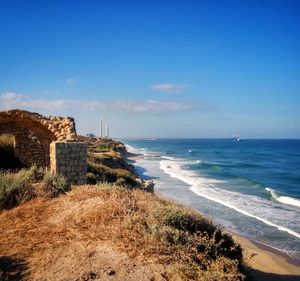 Scenic view of sea and hill against sky