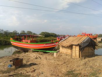 Boat moored on beach against sky