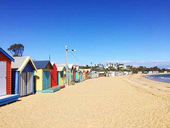 Colorful huts at beach against clear sky