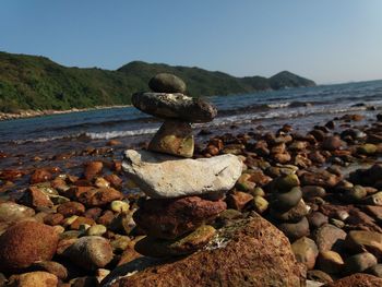 Stones on beach against sky