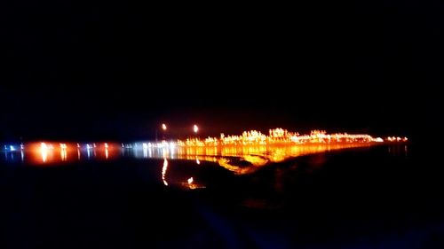 Illuminated city against sky at night