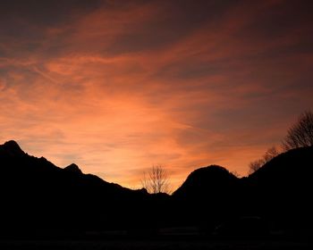 Scenic view of silhouette mountains against romantic sky at sunset