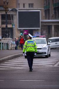 Rear view of man walking on road