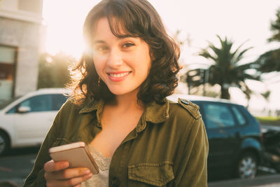 Portrait of smiling woman standing by car