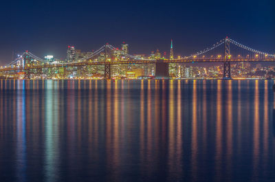 Illuminated suspension bridge over river at night