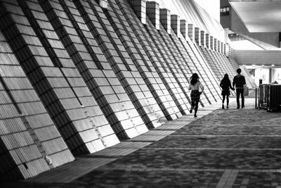 Three people walking through underground walkway