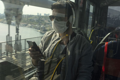 Man using mobile phone while standing by buildings