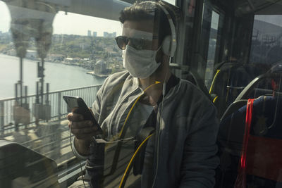 Man wearing mask while traveling in train