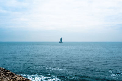 Sailboat in sea against sky