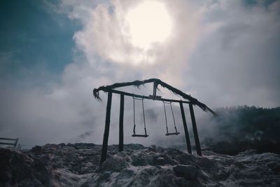 Low angle view of swing against sky