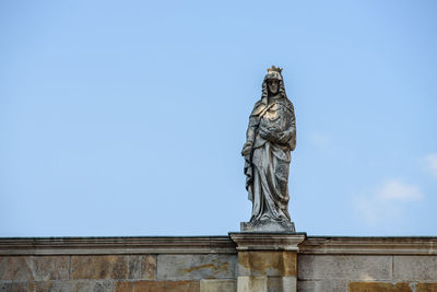 Low angle view of statue against blue sky