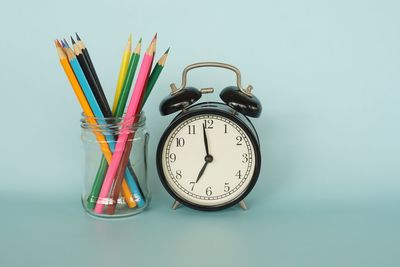 Close-up of clock on table against wall