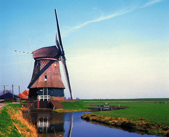 Traditional windmill on field against sky