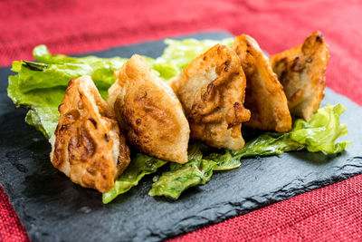 High angle view of deep fried chicken wings with lettuce served on slate