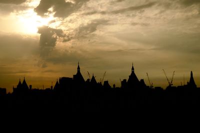 Silhouette of temple against cloudy sky