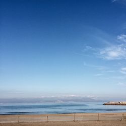 Scenic view of beach against clear blue sky