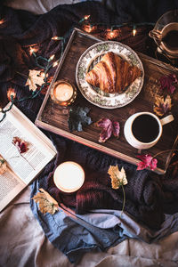 Coffee cup and croissant on table