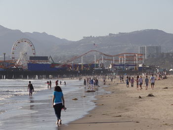 Group of people at beach against sky