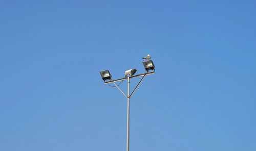 Low angle view of street light against clear blue sky