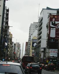 Traffic on road in city against sky