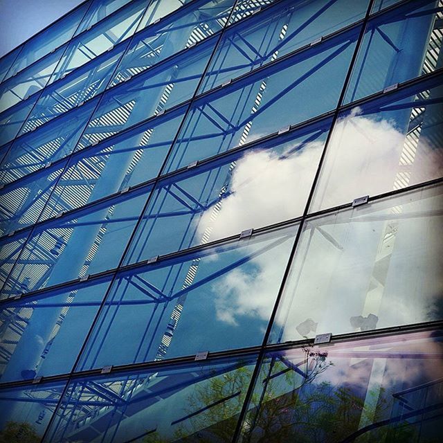 low angle view, architecture, built structure, sky, glass - material, modern, building exterior, cloud - sky, day, pattern, no people, part of, architectural feature, outdoors, metal, directly below, cloud, city, building