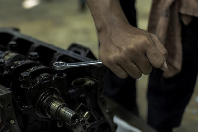 Cropped hands of mechanic repairing engine