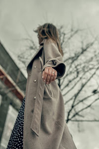 Midsection of woman holding umbrella standing in winter