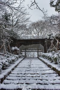 Snow covered footbridge against sky