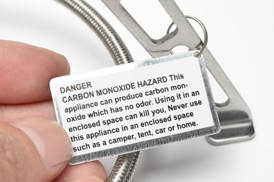 Cropped hand holding label with text over white background