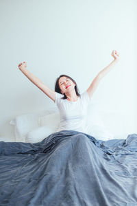 Woman sitting on bed at home