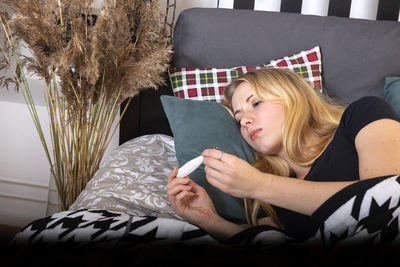 Woman lying down on bed at home