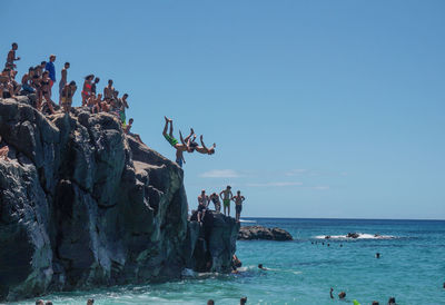 People at beach against sky