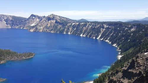 High angle view of lake by mountains against sky