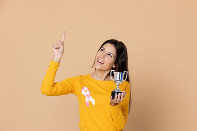 Portrait of a smiling young woman against gray background